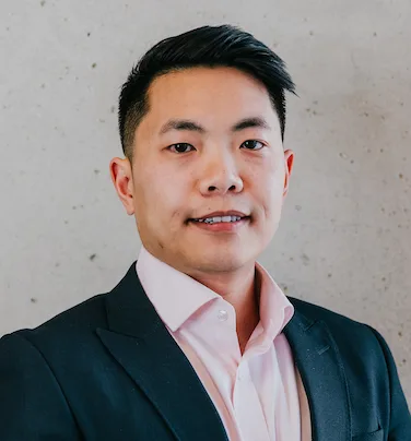 Man in a suit poses confidently, showcasing mcrally style against a textured background